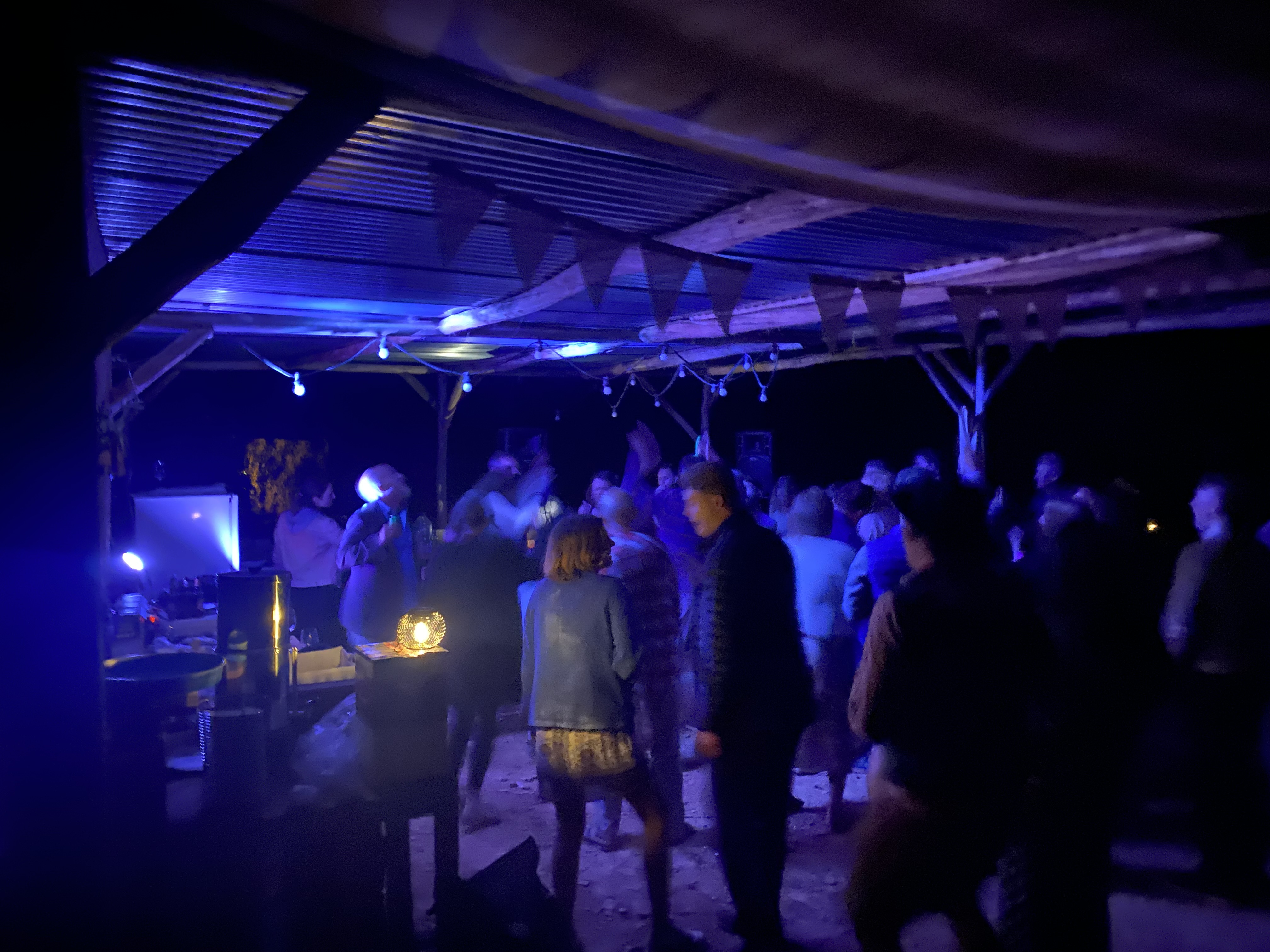 Guests dancing under string lights on the farm